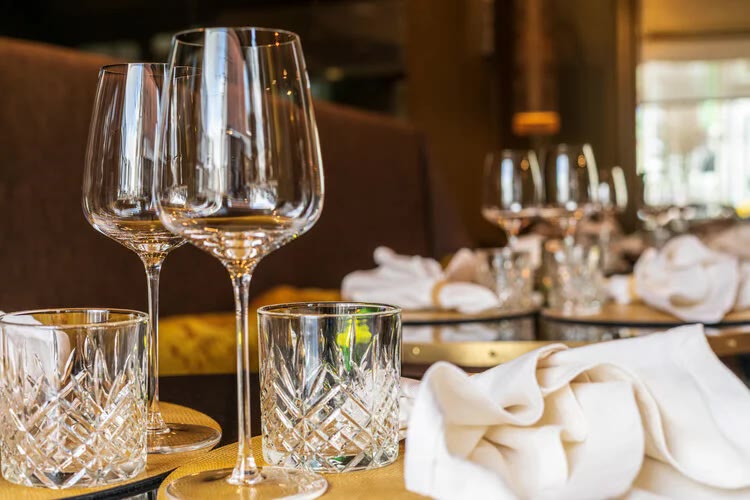 Gedekte tafel met kristallen glazen en witte servetten